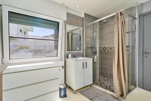 La salle de bains est pourvue d'une douche, d'un lavabo et d'une fenêtre. dans l'établissement Villa Spectacular Casa Negra, à Torrox Costa
