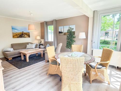 a living room with a table and chairs and a couch at Großzügige Whg. mit verglaster Veranda, geschützter Terrasse in Kühlungsborn