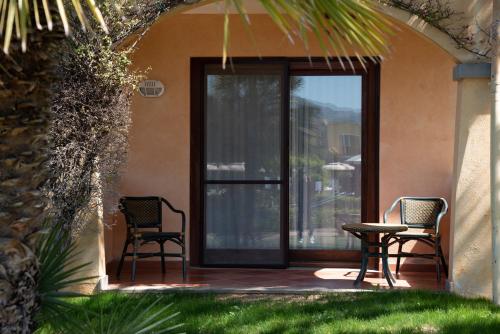 two chairs and a table on a patio at Hotel Santa Gilla in Capoterra