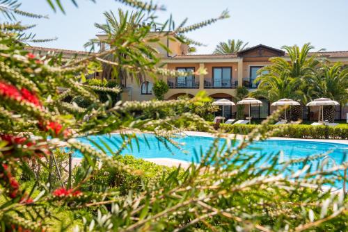 a resort with a swimming pool and a building at Hotel Santa Gilla in Capoterra
