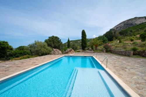 une piscine dans une villa avec une montagne en arrière-plan dans l'établissement Maisonnette en plein maquis vue splendide à 5 min du centre et de la plage, à Calvi