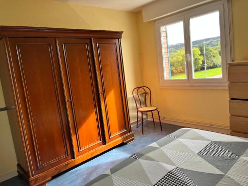 a bedroom with a large wooden cabinet and a window at Camping De Collignon in Cherbourg en Cotentin