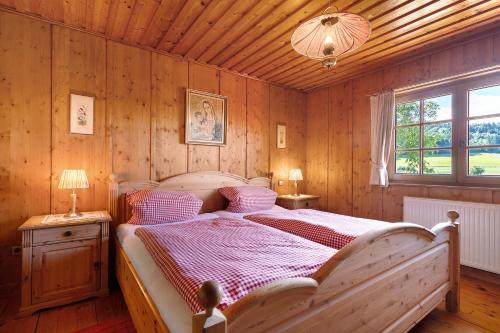 - une chambre avec un grand lit dans une pièce dotée de murs en bois dans l'établissement Ferienhaus Charlotte, à Zell am Harmersbach
