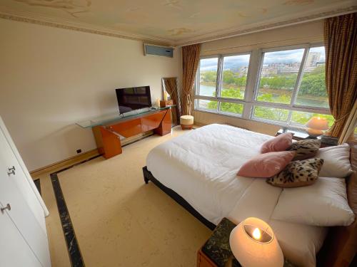 a bedroom with a bed and a tv and a large window at Les Amoureux de Paris in Paris
