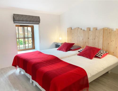 EnnezatにあるChemin des Ormeauxのベッドルーム1室(赤い枕のベッド2台付)