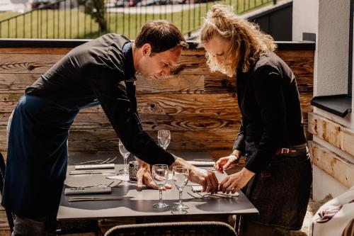 a man and woman standing around a table with wine glasses at LaMonte Luxury Apartments in Kitzbühel