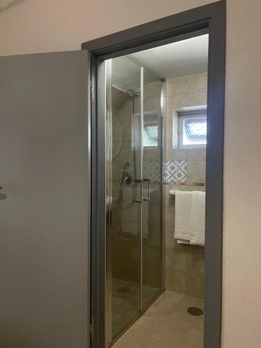 uma casa de banho com um chuveiro e uma porta de vidro em Masseria Don Sante em Fasano