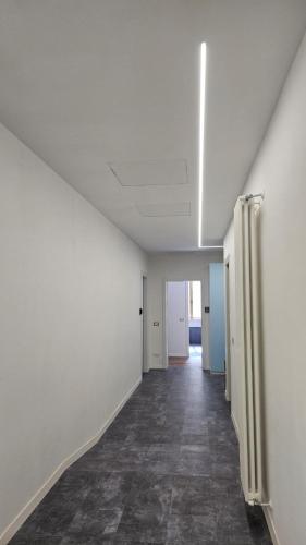 an empty hallway with white walls and a tile floor at Casa Zagni in Piombino