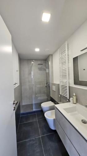 a bathroom with two sinks and a toilet and a shower at Casa Zagni in Piombino