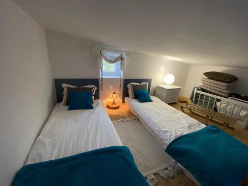 2 camas en una habitación pequeña con almohadas azules en Domek całoroczny blisko lasu i morza na urokliwej działce 4300 m2, en Orlinki