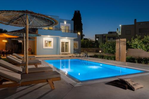 uma piscina com duas cadeiras e um guarda-sol em Villa Ethria Rhodes em Afantou
