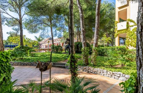 statua ptaka w parku z drzewami w obiekcie VIVA Cala Mesquida Suites & Spa Adults Only 16 w Cala Mesquida