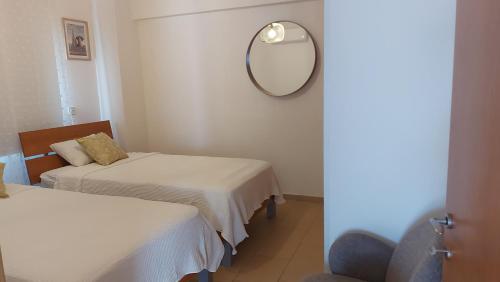 a room with two beds and a mirror and a chair at Nissi 3 Pool View 2 Bedroom Apartment with Large Veranda in Ayia Napa