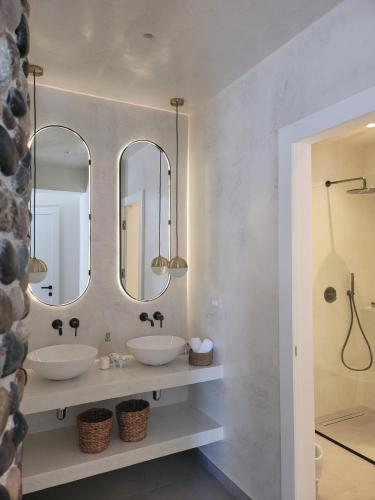 a bathroom with two sinks and two mirrors at Artis Blue Relax in Himare