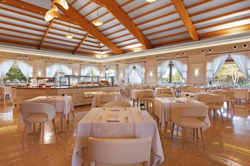 een eetkamer met witte tafels en stoelen bij VIVA Cala Mesquida Suites & Spa Adults Only 16 in Cala Mesquida
