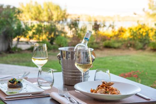 a table with a plate of food and a bottle of wine at Hotel Santa Gilla in Capoterra