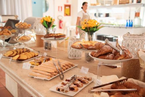 a table filled with lots of different types of pastries at Hotel Santa Gilla in Capoterra