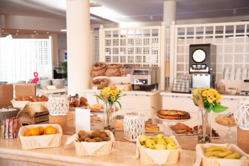 a table with baskets of fruits and vegetables on it at Hotel Santa Gilla in Capoterra