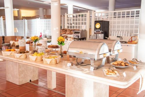 a buffet line with food on a counter in a store at Hotel Santa Gilla in Capoterra