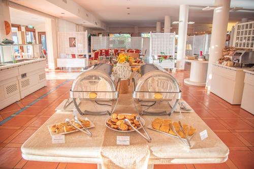 a bakery with a bunch of pastries on a table at Hotel Santa Gilla in Capoterra