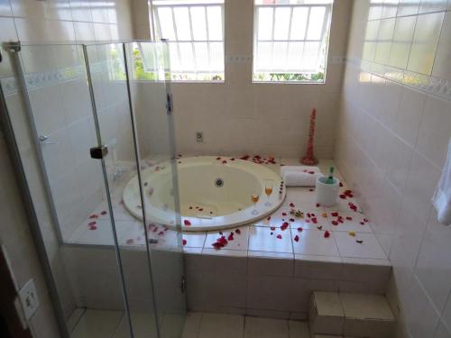 a bathroom with a bath tub with flowers on the floor at Hotel Nuar in Betim