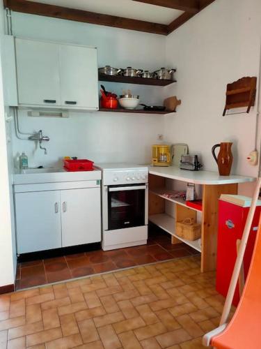 une cuisine avec des armoires blanches et un four à plaques de cuisson dans l'établissement Appartement dans maison individuelle, à Recoubeau-Jansac