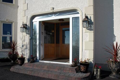an open door to a house with potted plants at Caldra B&B in Buncrana