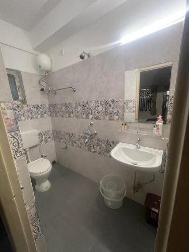 a bathroom with a toilet and a sink at Chopson's Parc in Thākurdwari