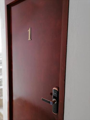 a red door with the number one on it at B1-Departamento Bolognesi in Chiclayo
