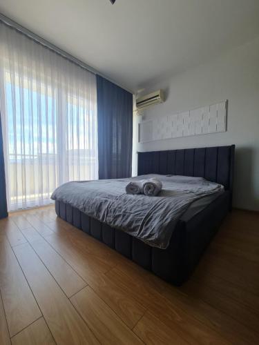 a bed in a bedroom with a large window at Apartment 06 in Gjilan
