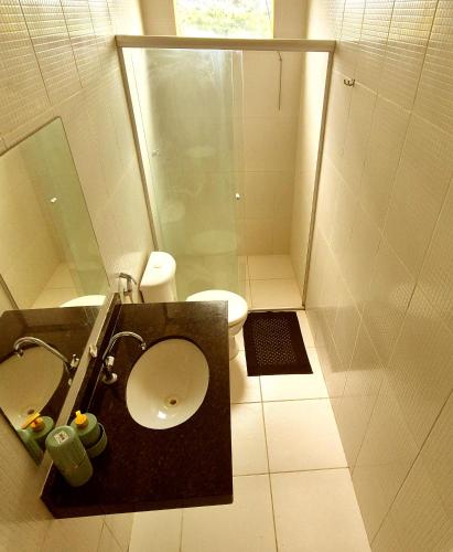 a bathroom with a toilet and a shower and a sink at Atalaia Vibes in Salinópolis
