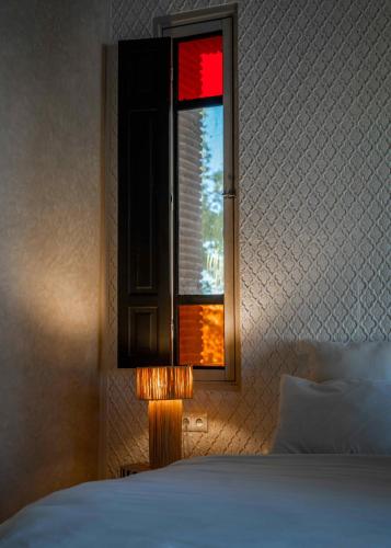 a bedroom with a window and a lamp next to a bed at Riad Jawad & Spa in Marrakech