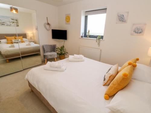 een slaapkamer met een groot wit bed en een grote spiegel bij Newquay~Near Beach & Town Centre~Parking in Newquay