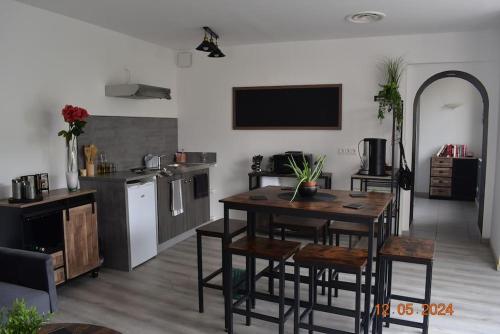 un salon avec une table et une cuisine dans l'établissement Charmant RDC au Cœur du village, à Soual