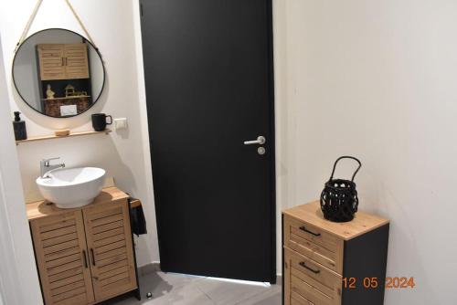 La salle de bains est pourvue d'une porte noire et d'un lavabo. dans l'établissement Charmant RDC au Cœur du village, à Soual