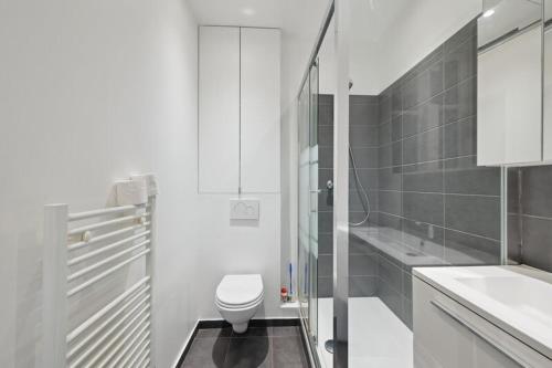 une salle de bain blanche avec des toilettes et un lavabo dans l'établissement 540 Suite Meridien - Superbe Appartement à Paris, à Paris