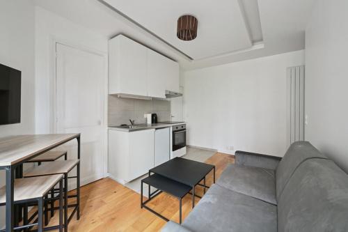 un salon avec un canapé et une cuisine dans l'établissement 540 Suite Meridien - Superbe Appartement à Paris, à Paris