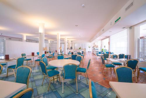 a dining room with tables and chairs in a building at Hotel Santa Gilla in Capoterra
