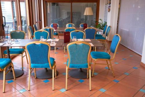 a room with wooden tables and blue chairs at Hotel Santa Gilla in Capoterra