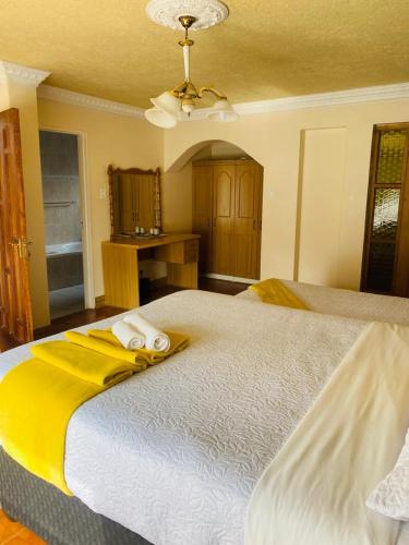 ein Schlafzimmer mit einem großen Bett mit Handtüchern darauf in der Unterkunft THE HAVEN GUEST HOUSE NKOYOYO in Mbabane