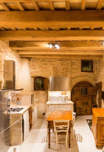 a kitchen with a table and a brick wall at The Monastery - Unique Vacation Home in Monteprandone
