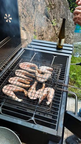 a grill with a bunch of food and a bottle of wine at Colonno Panoramica Lago Di Como in Colonno