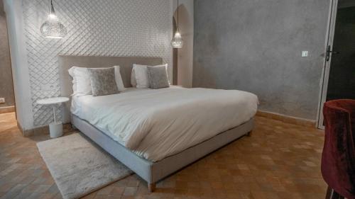 a bedroom with a large bed with white sheets and pillows at Riad Jawad & Spa in Marrakech