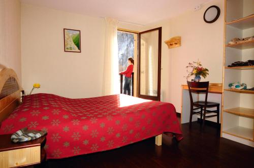 een vrouw die uit het raam van een slaapkamer kijkt bij VTF Les Esquirousses in Arvieux