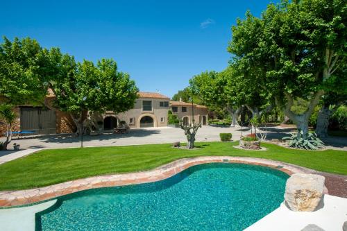 - une piscine dans une cour avec des arbres et une maison dans l'établissement Gîte Cerise - Maison climatisée avec piscine, à Istres