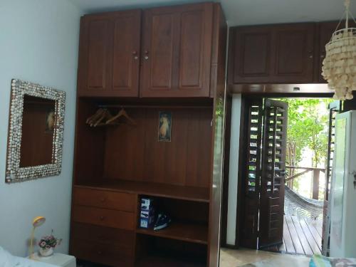 a room with a large wooden cabinet with a glass door at Serrote Breezes Apartamento 04 in Jericoacoara