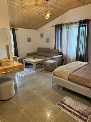 a living room with a bed and a couch at Qyteza Guest House & Camping in Shkodër