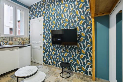 un salon avec une télévision sur un mur dans l'établissement 548 Suite Dulac - Superbe Appartement à Paris, à Paris