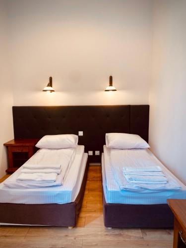 two beds in a room with two lights on the wall at Hotel Pałac w Myślęcinku in Bydgoszcz