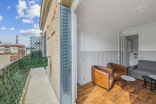 - un salon avec un balcon et un canapé dans l'établissement 550 Suite Quinault - Superbe Appartement à Paris, à Paris